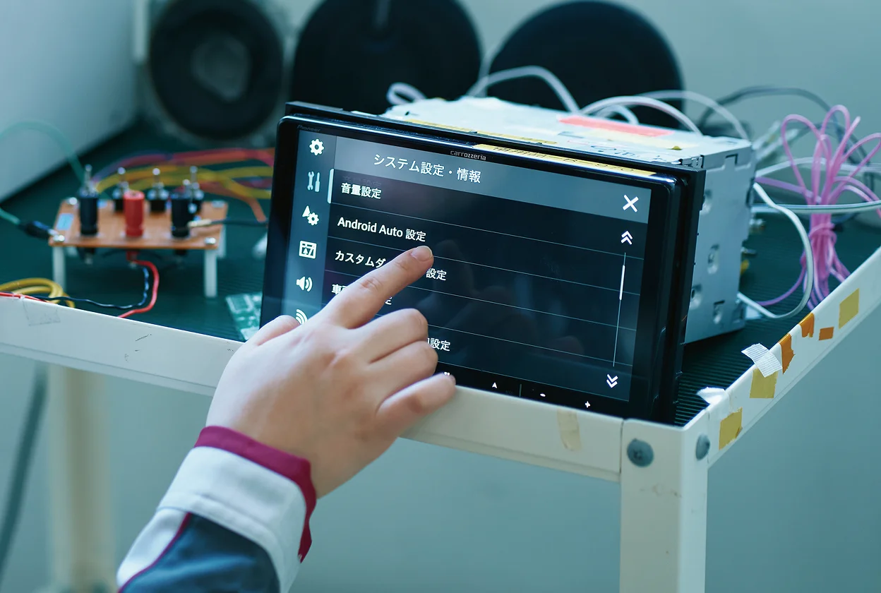 車載ナビの画面を操作する開発者の手元