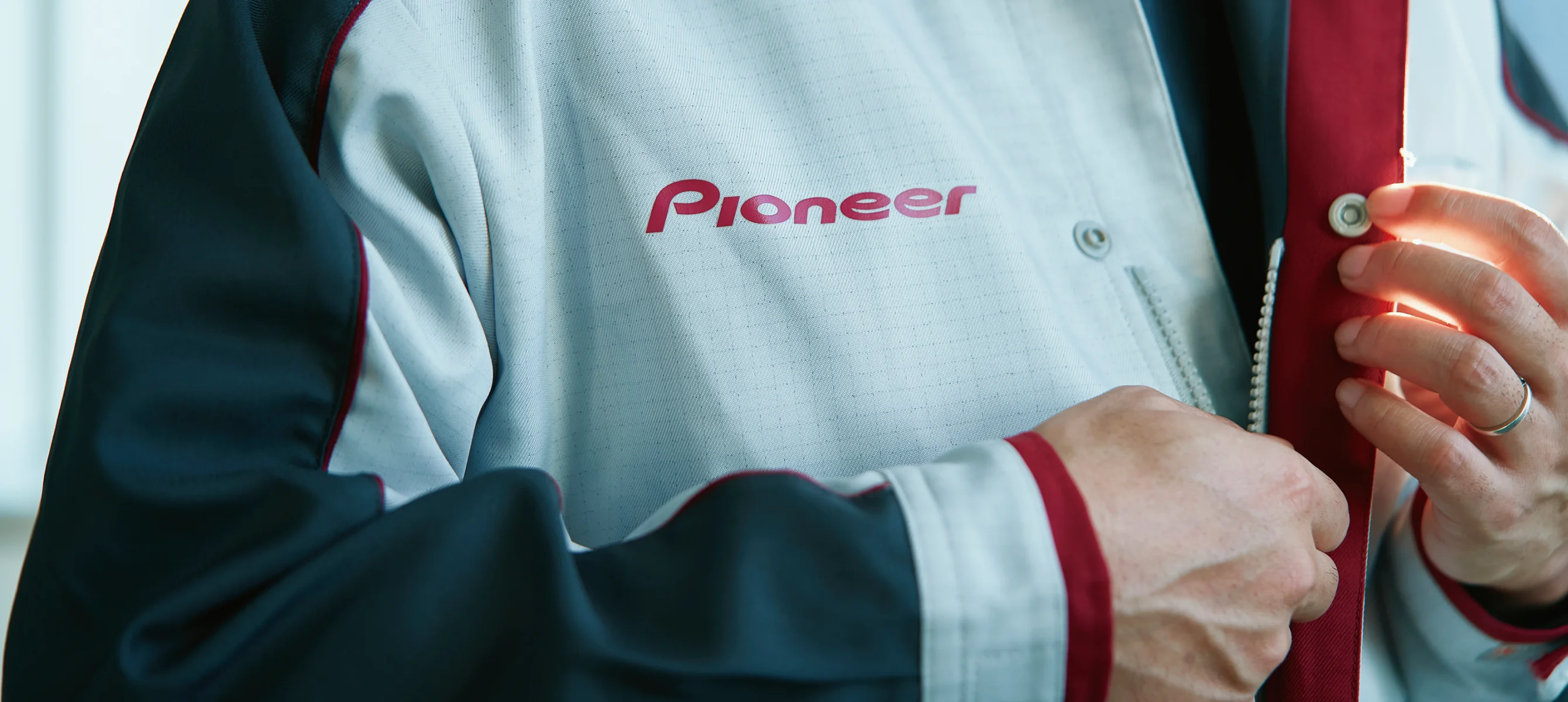 Pioneerロゴ入りの制服を着用する社員